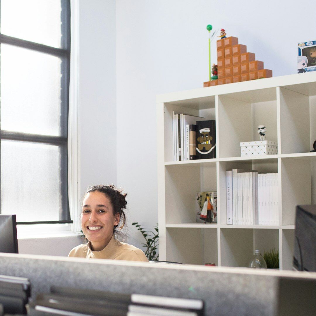 Small editorial team of four people smiling in a bright office
